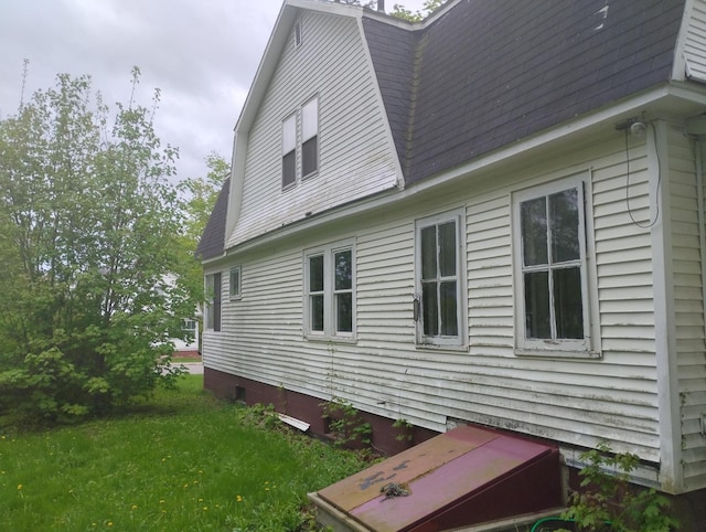 105 Broadway, Baileyville, ME 04694 - view of side of home featuring a gambrel roof, a shingled roof, and a yard