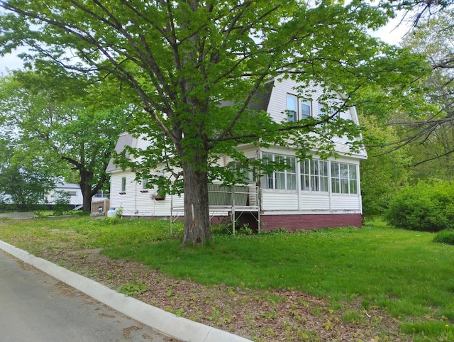 105 Broadway, Baileyville, ME 04694 - view of front of home with a sunroom, a gambrel roof, and a front lawn