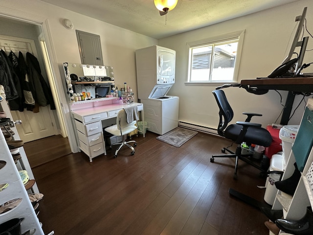 office featuring stacked washing maching and dryer, electric panel, dark wood-type flooring, and a baseboard radiator