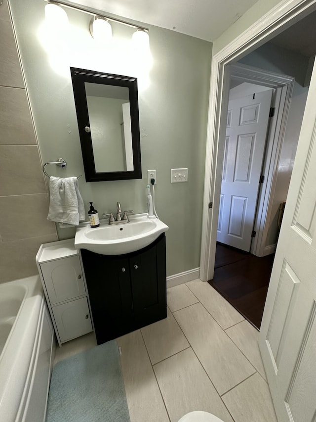 full bath with vanity, tile patterned flooring, and a bathtub