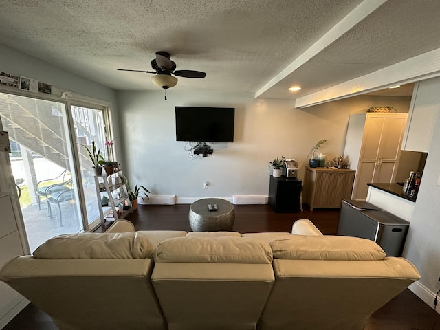 living area featuring a ceiling fan, a textured ceiling, baseboards, dark wood-style flooring, and recessed lighting