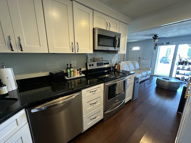kitchen featuring white cabinets, stainless steel appliances, and dark wood-style floors