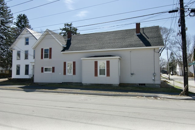 view of front of house with a chimney and a shingled roof