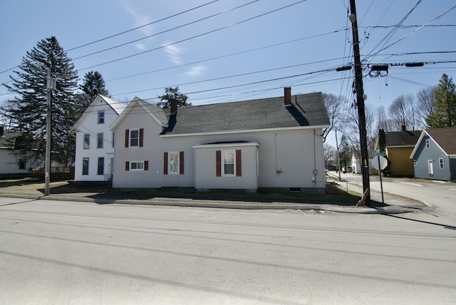 view of front of home featuring roof with shingles and a chimney