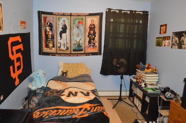 bedroom featuring a baseboard heating unit and wood finished floors