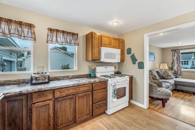 102 New Hampshire St, Millinocket, ME 04462 - kitchen featuring white appliances, light wood-style flooring, brown cabinets, and open floor plan