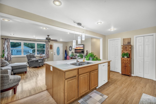 102 New Hampshire St, Millinocket, ME 04462 - kitchen with white dishwasher, open floor plan, light wood-style flooring, light countertops, and decorative light fixtures
