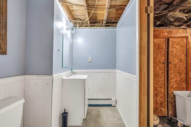 102 New Hampshire St, Millinocket, ME 04462 - bathroom with a baseboard radiator, vanity, wainscoting, and tile patterned floors