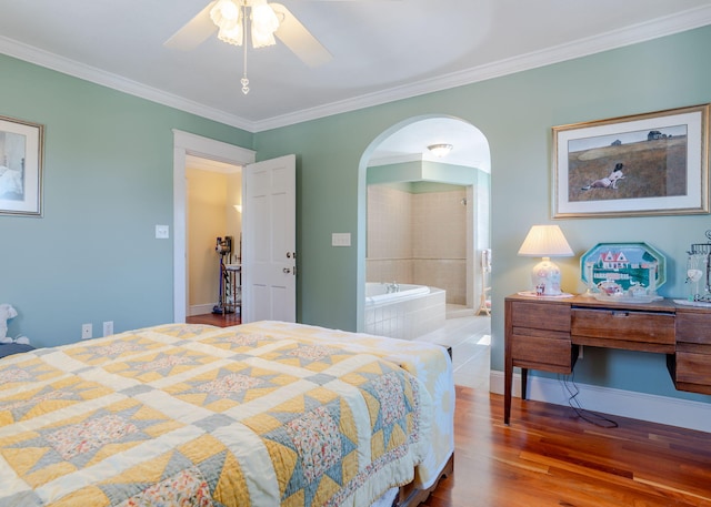 bedroom with baseboards, ornamental molding, arched walkways, and wood finished floors