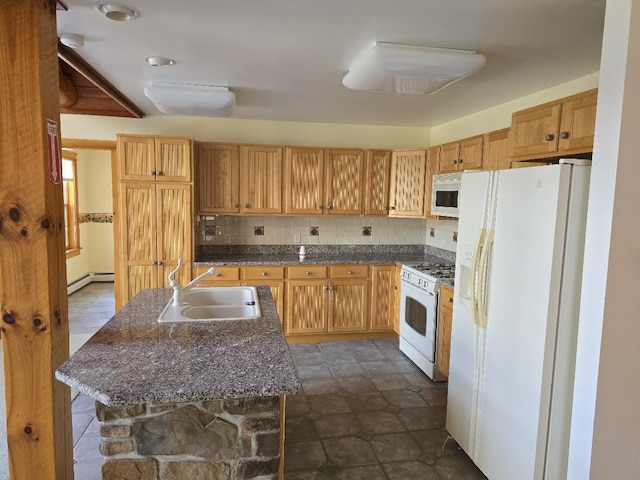 kitchen featuring tasteful backsplash, a sink, baseboard heating, white appliances, and an island with sink