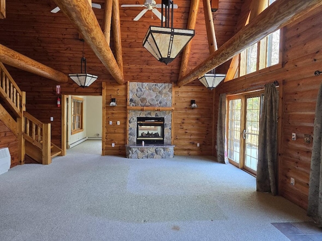 unfurnished living room featuring rustic walls, high vaulted ceiling, and carpet floors