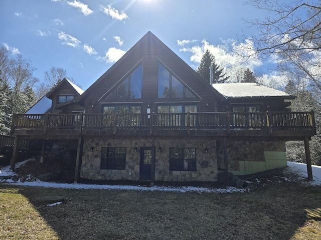 back of property featuring a wooden deck and stone siding