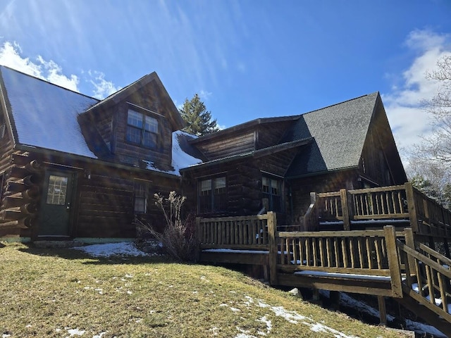 rear view of house with log exterior and a wooden deck