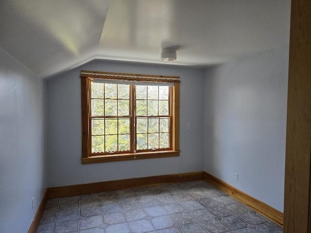 additional living space featuring vaulted ceiling and baseboards