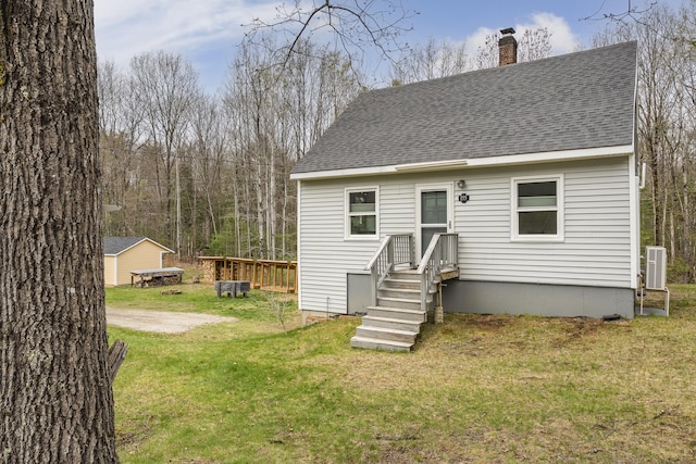 155 Saco Rd, Hollis, ME 04042 - back of house featuring a chimney, roof with shingles, a yard, and central AC unit