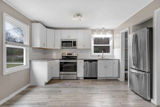 155 Saco Rd, Hollis, ME 04042 - kitchen with stainless steel appliances, a sink, light stone counters, tasteful backsplash, and white cabinets