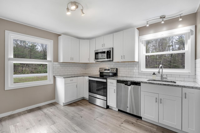 155 Saco Rd, Hollis, ME 04042 - kitchen with appliances with stainless steel finishes, a sink, light stone counters, decorative backsplash, and white cabinetry