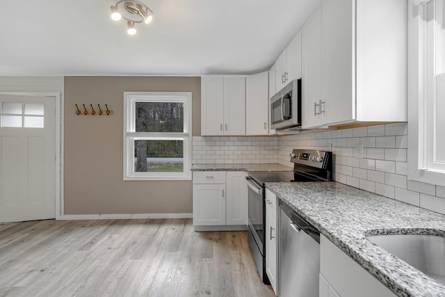 155 Saco Rd, Hollis, ME 04042 - kitchen featuring appliances with stainless steel finishes, white cabinets, decorative backsplash, and light wood-style floors