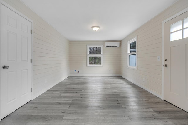 155 Saco Rd, Hollis, ME 04042 - entrance foyer with a wall mounted air conditioner, wooden walls, and wood finished floors