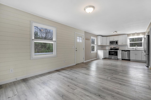 155 Saco Rd, Hollis, ME 04042 - unfurnished living room with light wood-style flooring, a sink, and baseboards