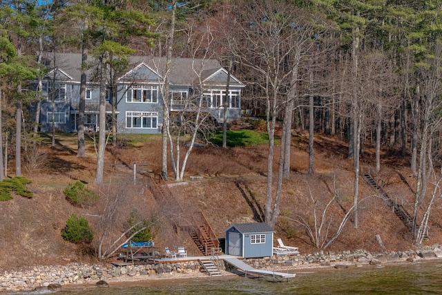 view of front of house with an outdoor structure, a storage shed, and stairs