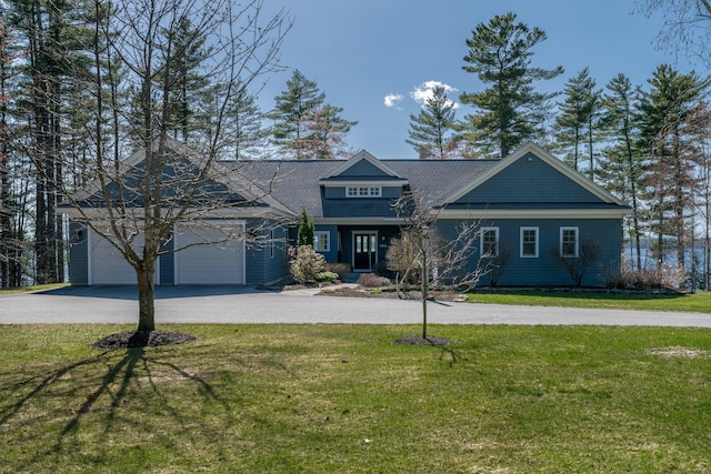craftsman-style home with a shingled roof, driveway, and a front yard