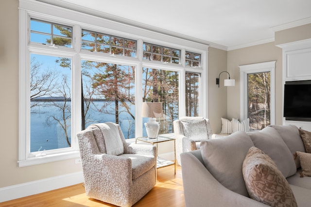 living room with baseboards, crown molding, and light wood finished floors