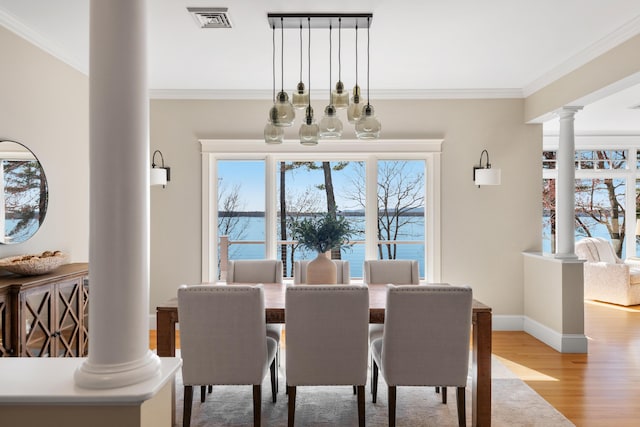dining area with decorative columns, ornamental molding, light wood-type flooring, baseboards, and visible vents