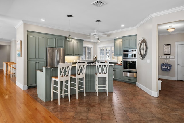 kitchen with ceiling fan, visible vents, stainless steel appliances, baseboards, and ornamental molding