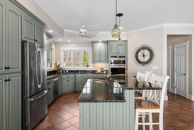 kitchen with a kitchen breakfast bar, ceiling fan, a center island, ornamental molding, and appliances with stainless steel finishes