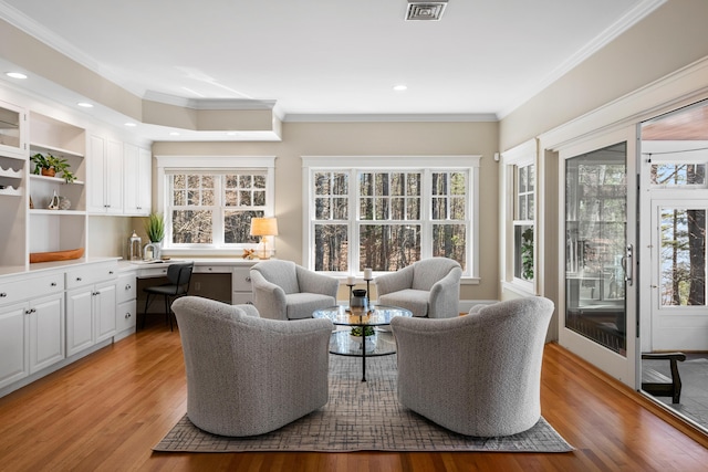 interior space with crown molding, visible vents, a wealth of natural light, and light wood-type flooring