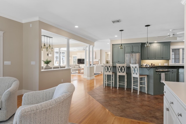 kitchen featuring a ceiling fan, visible vents, ornamental molding, freestanding refrigerator, and open floor plan