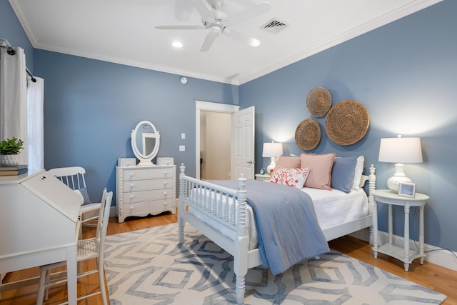 bedroom featuring crown molding, visible vents, ceiling fan, and wood finished floors