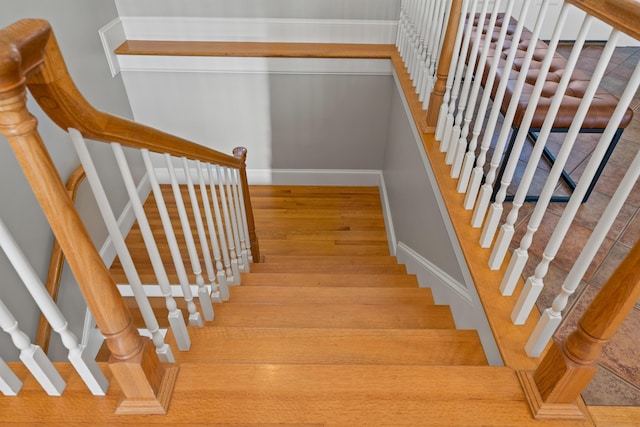 stairs with wood finished floors and baseboards