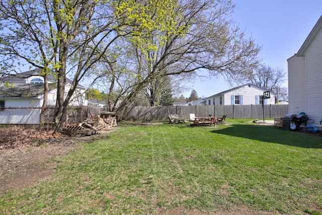 view of yard with a fenced backyard and a fire pit