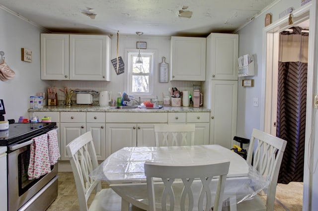 kitchen featuring white cabinetry, ornamental molding, a sink, and stainless steel range with electric stovetop