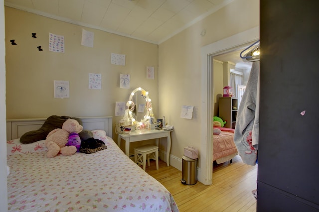 bedroom with crown molding and light wood-type flooring