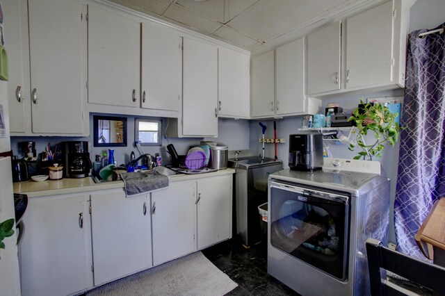 kitchen with light countertops, white cabinetry, and washing machine and dryer