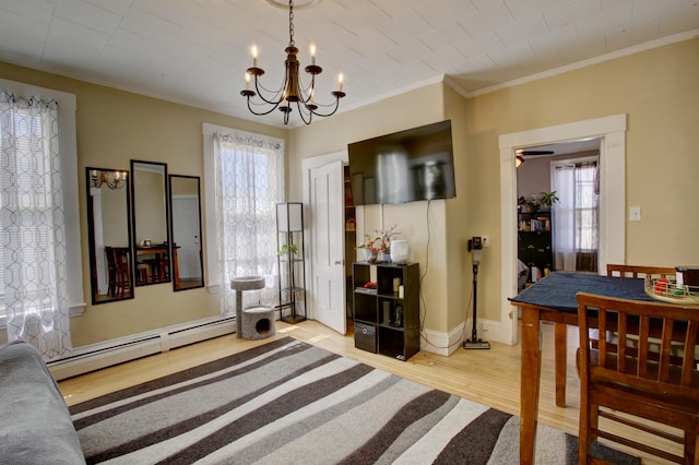 interior space featuring ornamental molding, wood finished floors, baseboards, a baseboard heating unit, and ceiling fan with notable chandelier