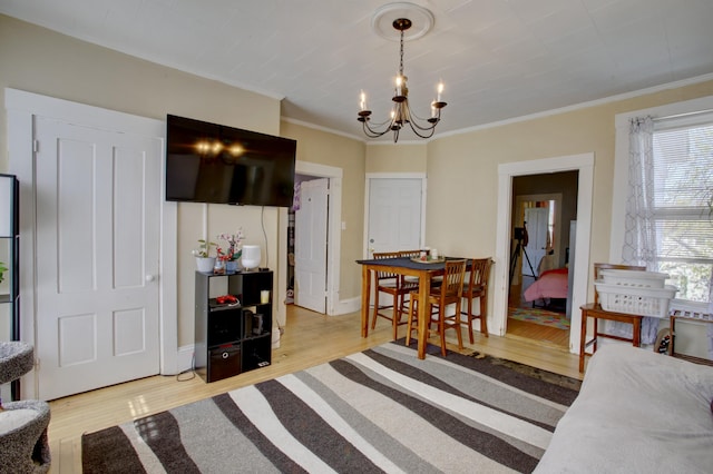 interior space featuring a notable chandelier, ornamental molding, and light wood-style floors
