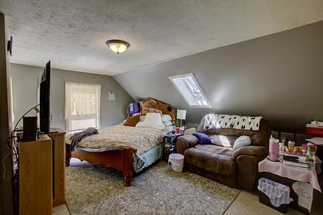 carpeted bedroom with a textured ceiling and lofted ceiling with skylight