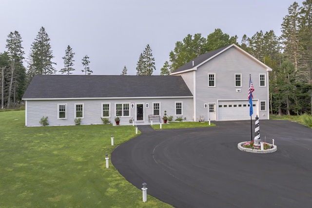 traditional home featuring a front lawn, driveway, and a garage