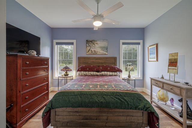 bedroom featuring ceiling fan, light wood-type flooring, and baseboards