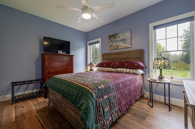 bedroom featuring baseboards, wood finished floors, and a ceiling fan