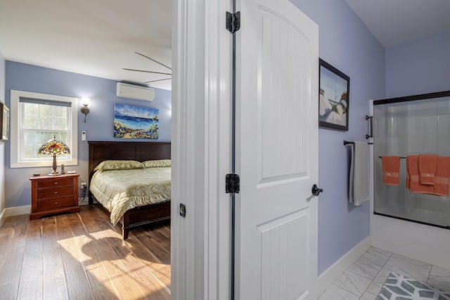 bedroom with baseboards and a wall mounted air conditioner