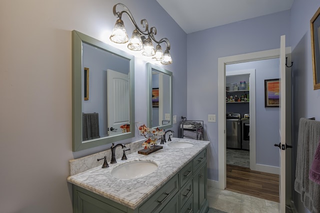 bathroom featuring double vanity, washer and clothes dryer, and a sink