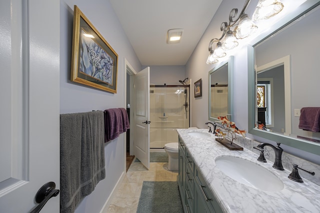 bathroom with double vanity, toilet, a shower stall, and a sink