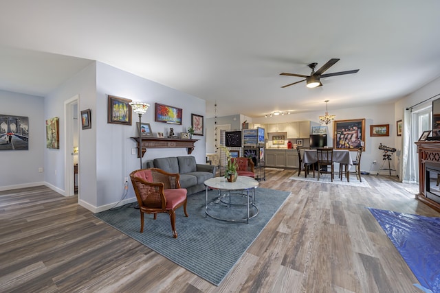 living room with baseboards, wood finished floors, ceiling fan, and a fireplace
