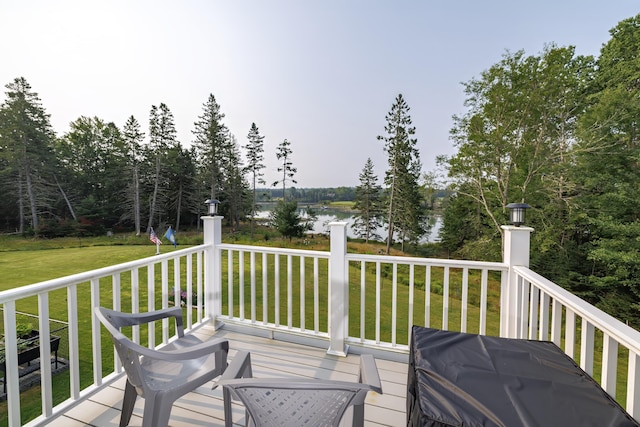 deck with a water view and a lawn