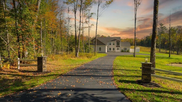 view of front of home featuring a yard, fence, and driveway